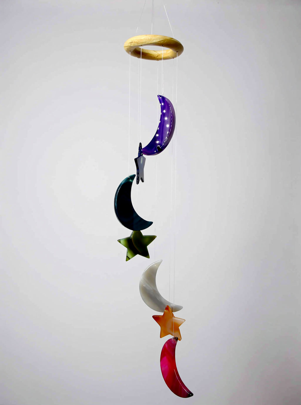 Decorative wind chime with colorful stars and moons on a plain background