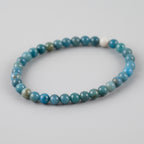 Blue beaded bracelet on a light gray background