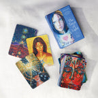 The Tarot of Light oracle card deck and several illustrated cards arranged on a light fabric background. The box shows a blue-toned portrait and the card backs feature colorful abstract and cosmic artwork.