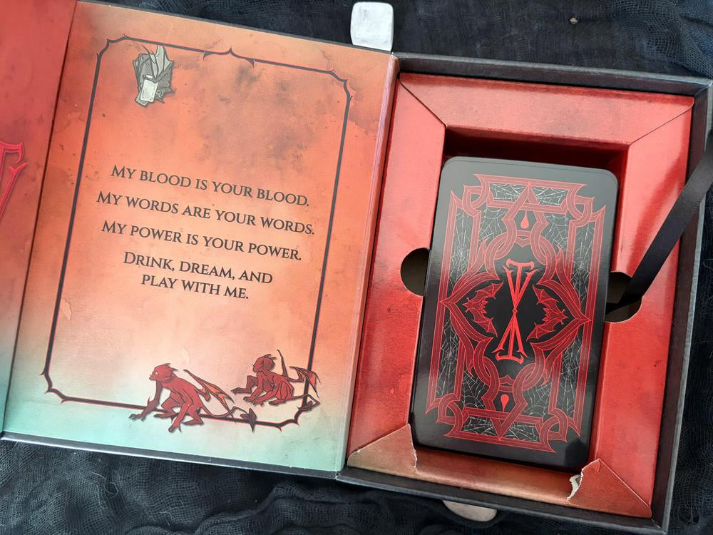 A close-up of a red and black decorative box or case with printed text on the lid, photographed indoors against a dark background.