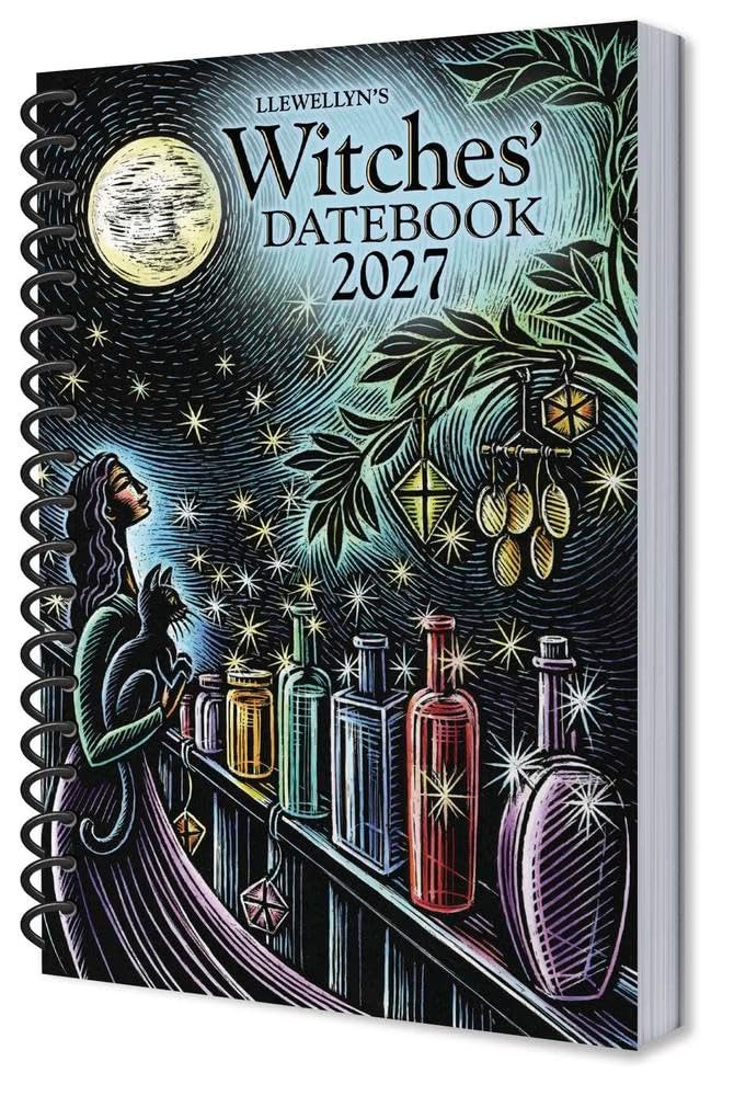 A spiral-bound 2027 'Witches Datebook' by Llewellyn's, featuring a detailed fantasy illustration of a witch, cat, potion bottles, and stars under a full moon.