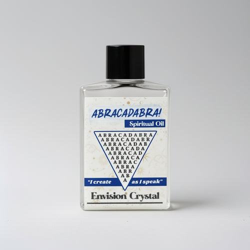 Bottle of 'Abracadabra!' spiritual oil with a black cap on a gray background