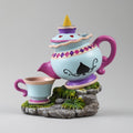 Colorful teapot and cup set with decorative elements on a gray background