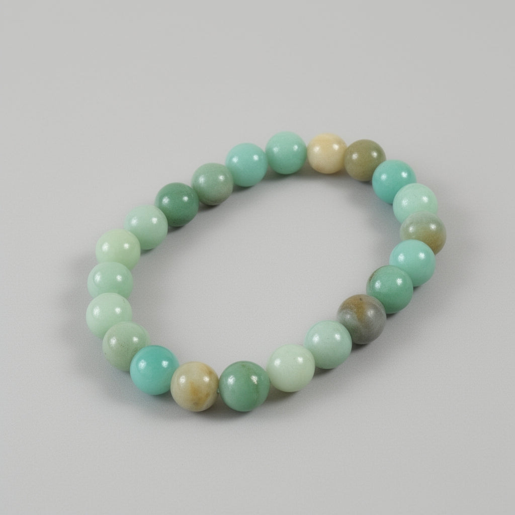 Beaded bracelet with green and beige beads on a gray background