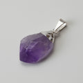 Purple teardrop pendant with silver setting on a light gray background