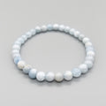 Beaded bracelet with light blue and white beads on a gray background