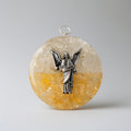 Round pendant with angelic design on a textured beige and orange stone background