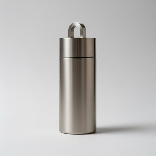 Stainless steel container with a lid on a light gray background