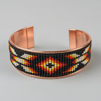 Beaded bracelet with copper accents on a gray background