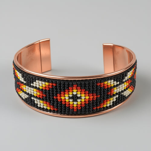 Beaded bracelet with copper accents on a gray background