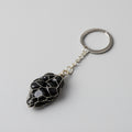 Keychain with a black stone pendant on a gray background