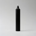 Black candle with a white wick on a light gray background