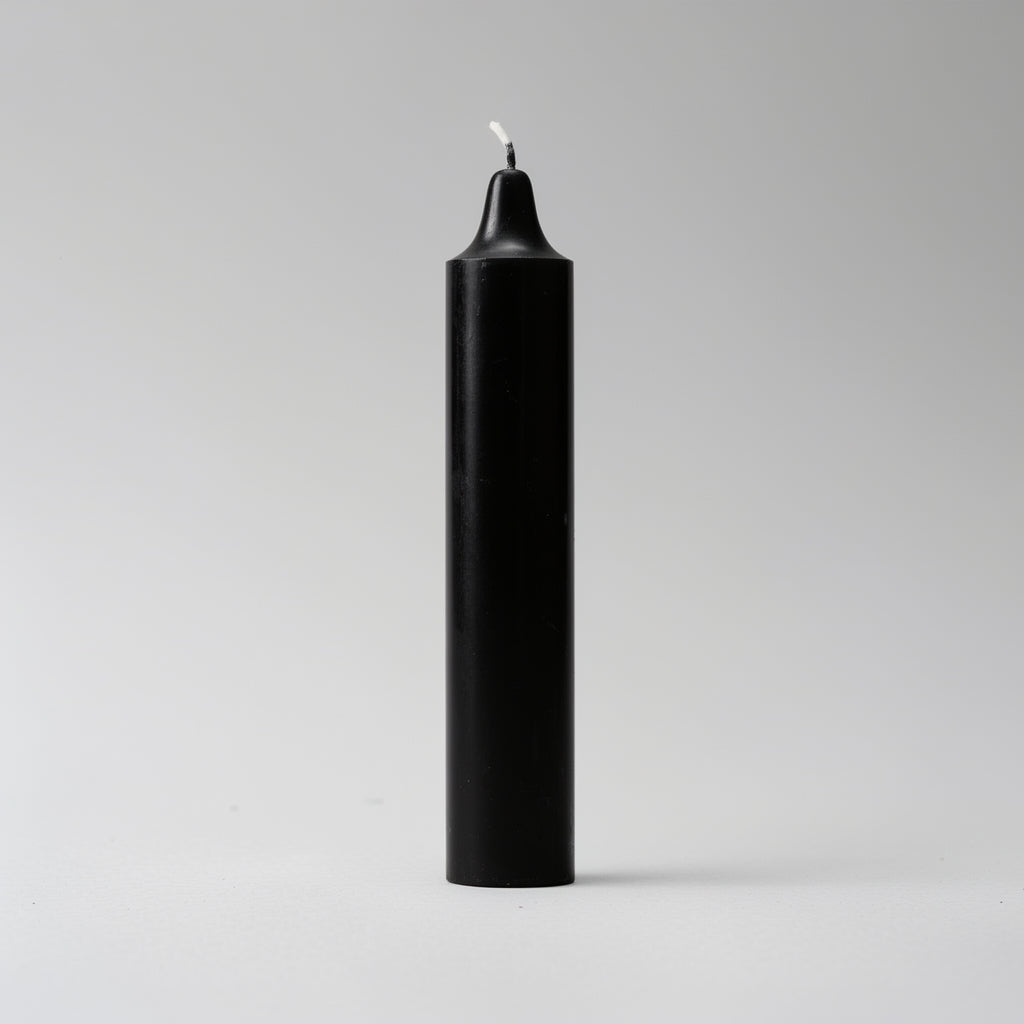 Black candle with a white wick on a light gray background