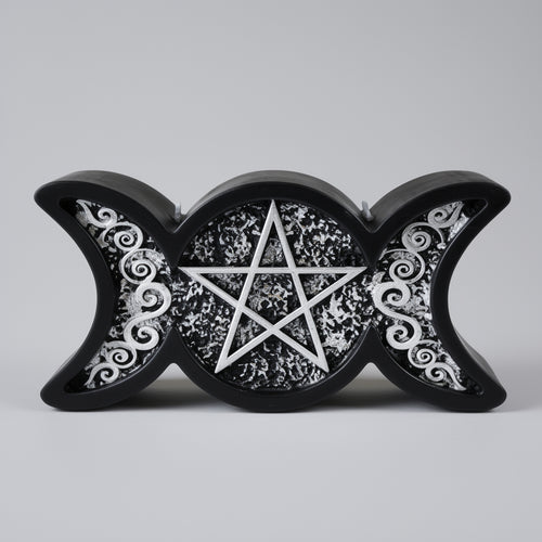A black triple moon candle with a pentagram design on a gray background