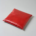 A sealed bag of red powder on a gray background
