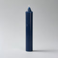 Navy blue candle on a light gray background