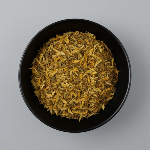 Black bowl filled with dried yellow flowers on a gray background