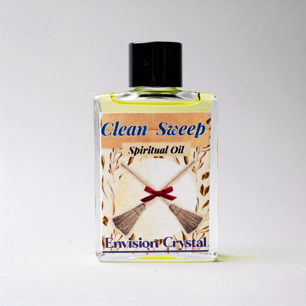 Bottle of 'Clean Sweep' spiritual oil with a broom and ribbon design on the label against a white background.