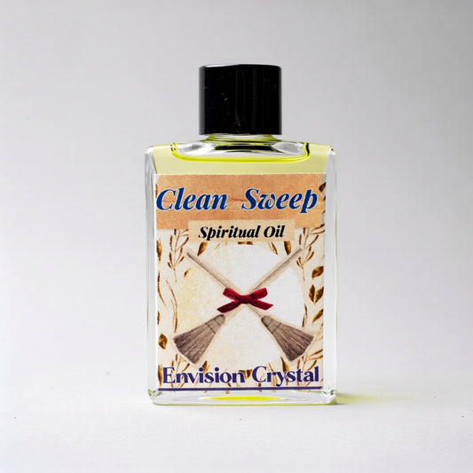 Bottle of 'Clean Sweep' spiritual oil with a broom and ribbon design on the label against a white background.