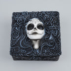 Decorative box with a skull design and floral patterns on a white background