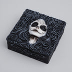 Decorative box with a skull design and floral patterns on a light gray background