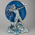 Silver statue of a figure with a deer in front of a blue circular background