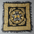 Decorative black and gold scarf with central emblem on a gray background