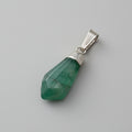 Green stone pendant with silver setting on a gray background