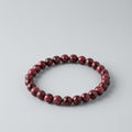 Red beaded bracelet on a light gray background