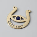 Brass good luck horseshoe with a blue stone on a gray background