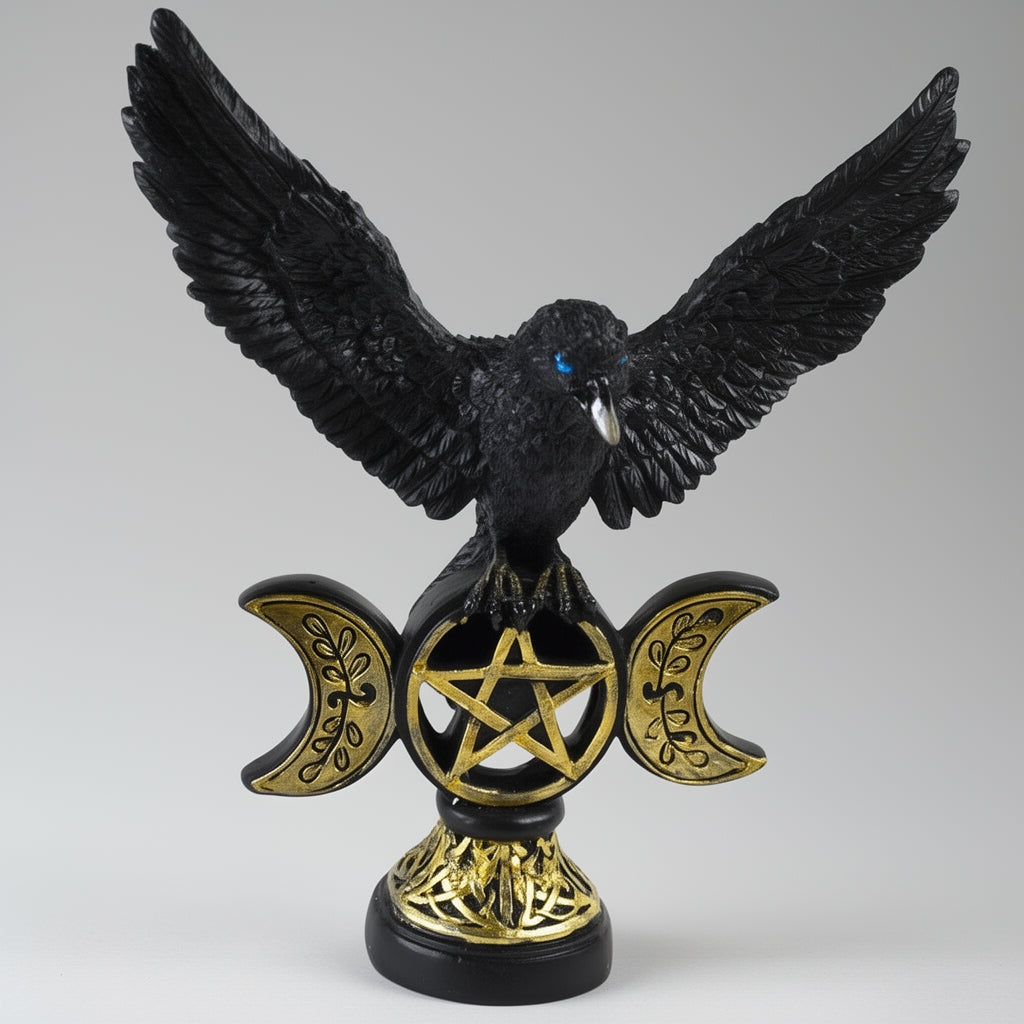 Crow figurine with gold pentacle and moon symbols on a gray background