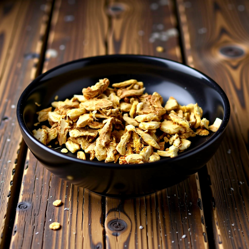 Black bowl filled with ginger root split on a wooden surface