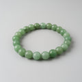 Green beaded bracelet on a light gray background