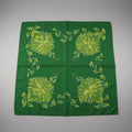 Green fabric with floral patterns on a gray background