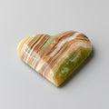 Heart-shaped stone with multicolored patterns on a gray background