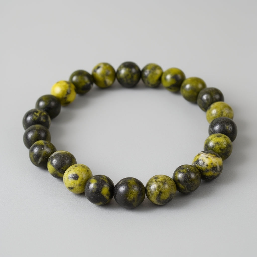 Beaded bracelet with green stones on a gray background