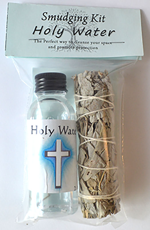 Smudging kit with holy water bottle and sage in a clear bag on a white background