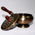 Bronze incense burner with a wooden handle on a white background