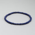 Blue beaded bracelet on a light gray background