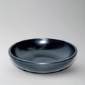 Black ceramic bowl on a light gray background