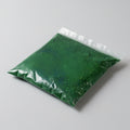 Green powder in a clear plastic bag on a gray background