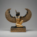 Statue of a winged figure with gold and black details on a gray background