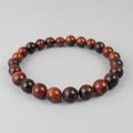 Bracelet with red and black beads on a light gray background