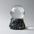 Decorative object with a glass sphere and leafy base on a gray background