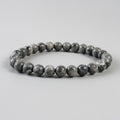 Beaded bracelet with gray and brown stones on a light gray background