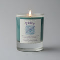 Candle in a glass jar with a 'Peace' label on a gray background