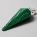 Green stone pendulum on a gray background