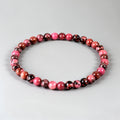 Beaded bracelet with pink and brown beads on a light gray background
