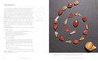 An interior page from a book or magazine spread titled 'Abundance,' showing a left column of text on a light background and a right-side photo of polished stones and a shell arranged on a dark slate surface. The page appears to be editorial or instructional content rather than a clean product-only shot.