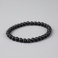 Black beaded bracelet on a light gray background